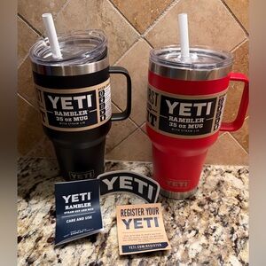 YETI Rambler 35 oz Mugs with Straw Lid - One is Black and the other one is Red.